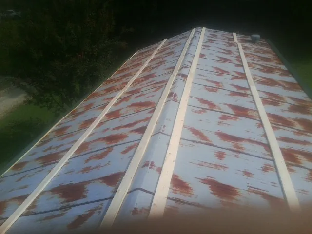Rusted metal roof panels with new wood purlins before replacement — Storm Damage Roof Repair in Mcville by Roofing Brothers
