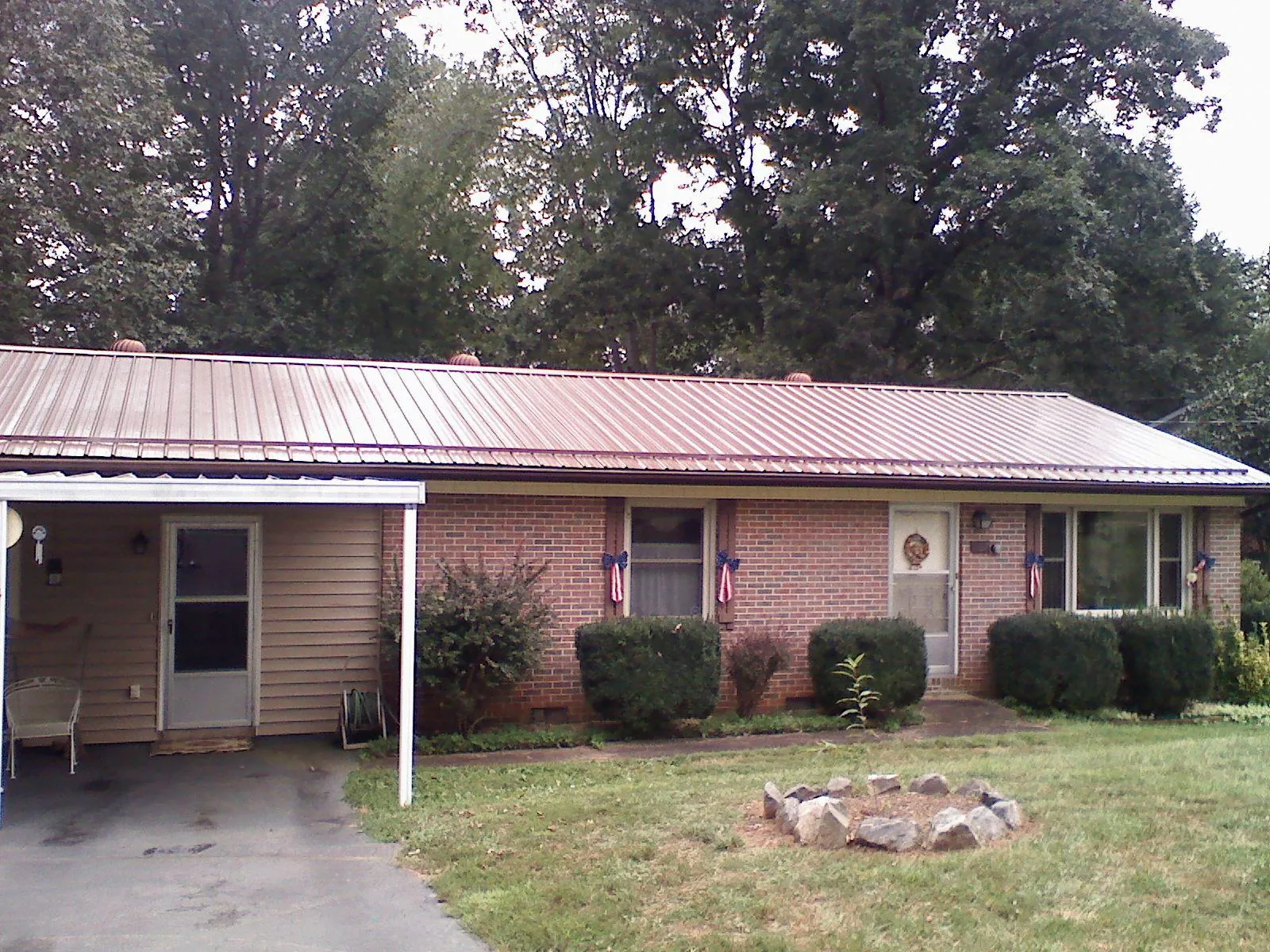 Bronze metal roof and carport on a brick ranch home — Roof Repair work by our crew in Mcville