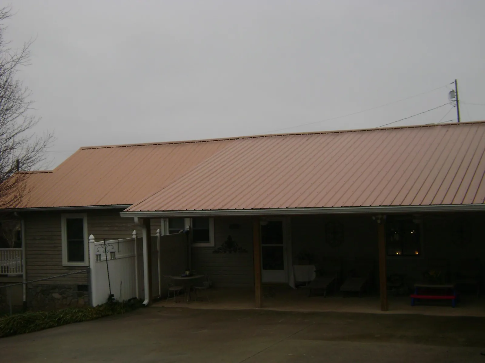 Copper toned metal roof over a wide covered patio in Mcville